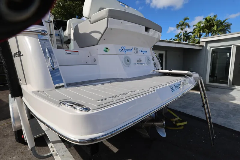 Slide: The Image of 2021 Regal 28 Express boat with swim platform, docked near modern building. - 5