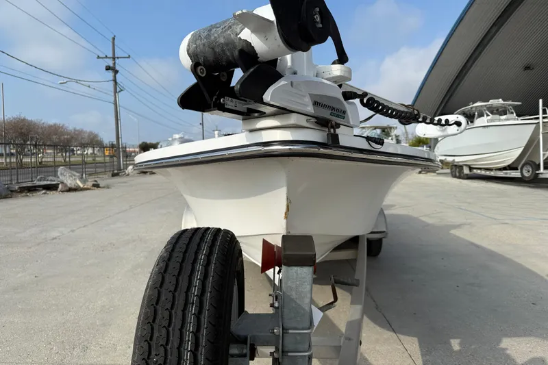 Slide: The Image of 2017 Blazer Bay 2200 boat on trailer with Minn Kota motor, parked outdoors. - 3