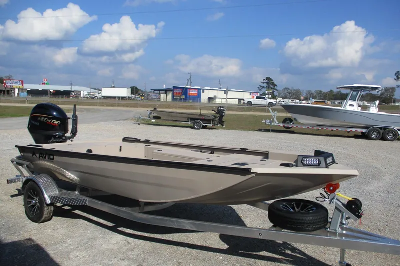 Slide: The Image of 2026 Avid 18 Commander boat on trailer, parked outdoors under a cloudy sky. - 1