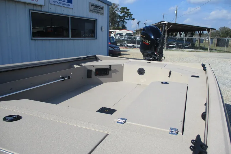 Slide: The Image of 2026 Avid 18 Commander boat with outboard motor, parked outside dealership. - 12