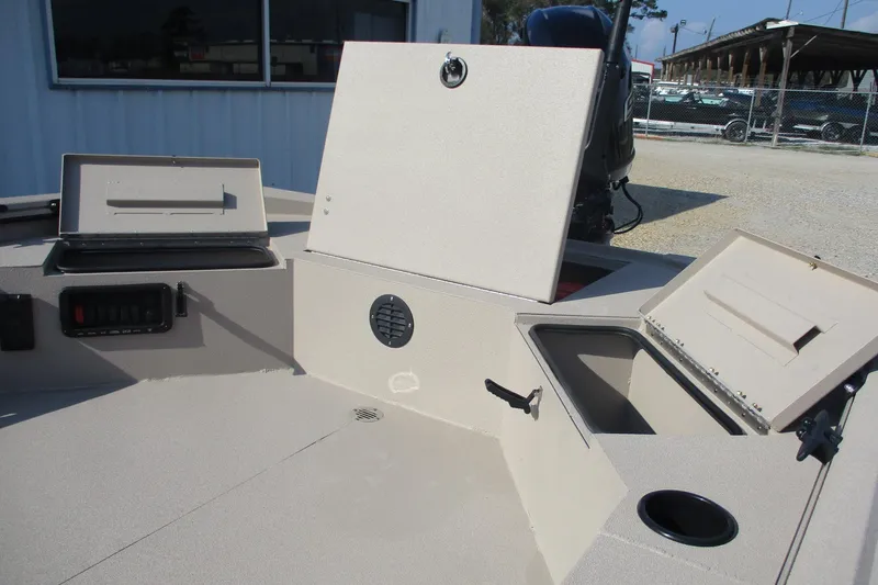 Slide: The Image of 2026 Avid 18 Commander boat interior with open storage compartments and cup holder. - 16