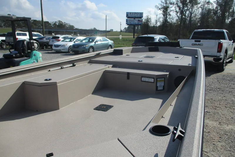 Slide: The Image of 2026 Avid 18 Commander boat interior with storage compartments, parked outdoors. - 8