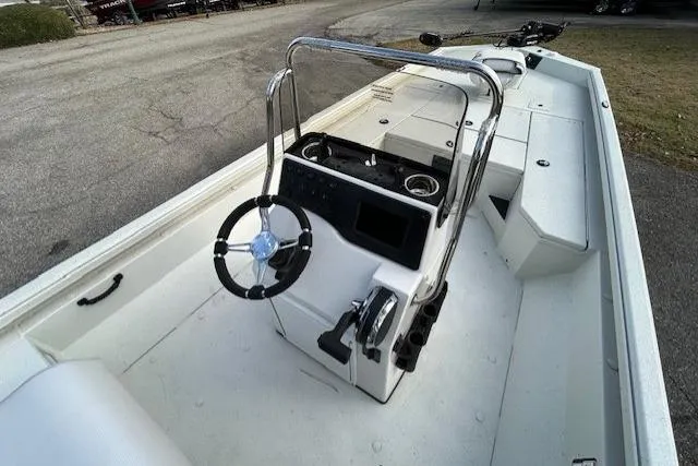Slide: The Image of 2025 Ranger RB210 boat interior with steering console and seating, parked on pavement. - 9
