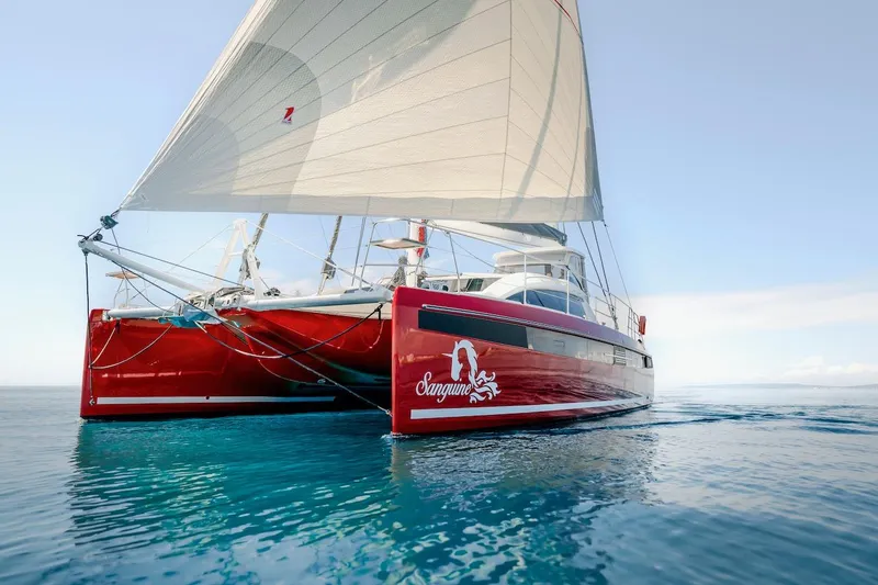 Slide: The Image of Red Privilege Signature 510 catamaran sailing on calm waters. - 68
