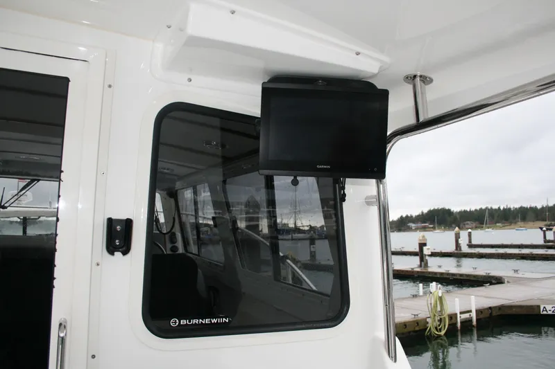Slide: The Image of 2019 Ocean Sport Roamer 30 boat deck with Yamaha engine, docked by the water. - 8