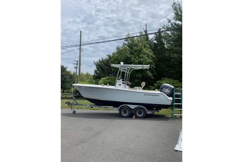 The Image of 2016 Sportsman Open 212 Center Console boat on trailer, parked outdoors. - 0