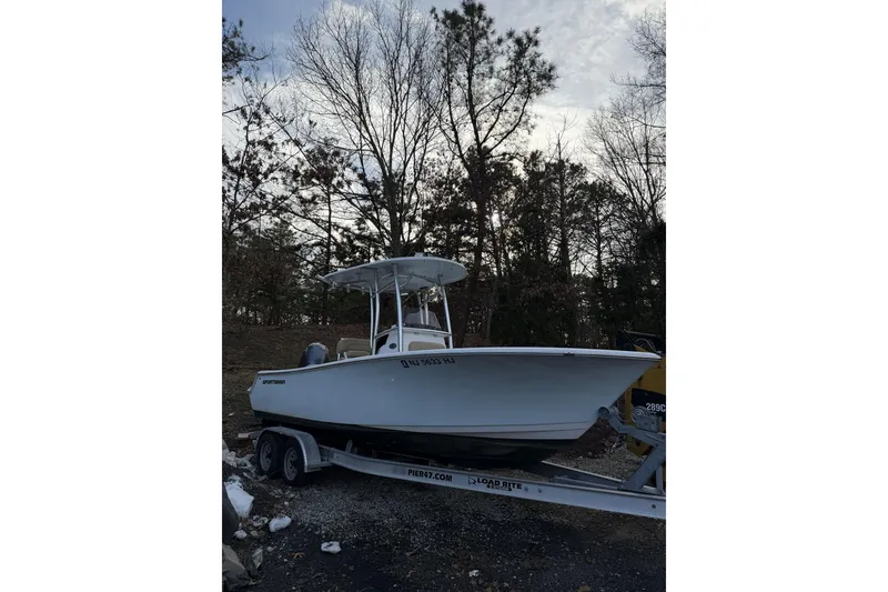Slide: The Image of 2016 Sportsman Open 212 Center Console boat on trailer, parked outdoors. - 2