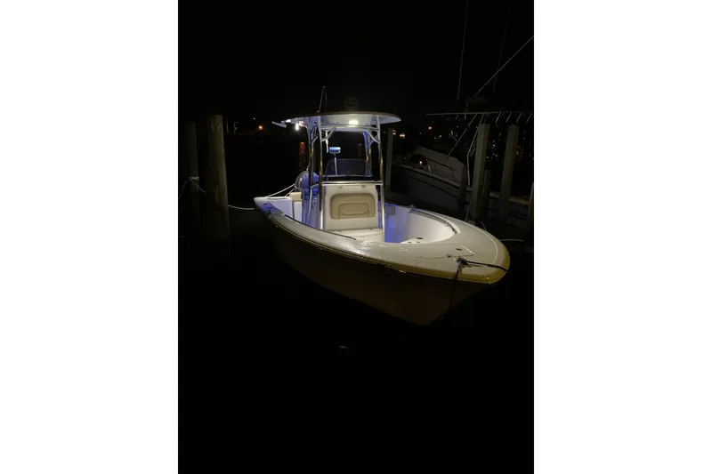 Slide: The Image of 2016 Sportsman Open 212 Center Console boat illuminated at night, docked in a marina. - 5