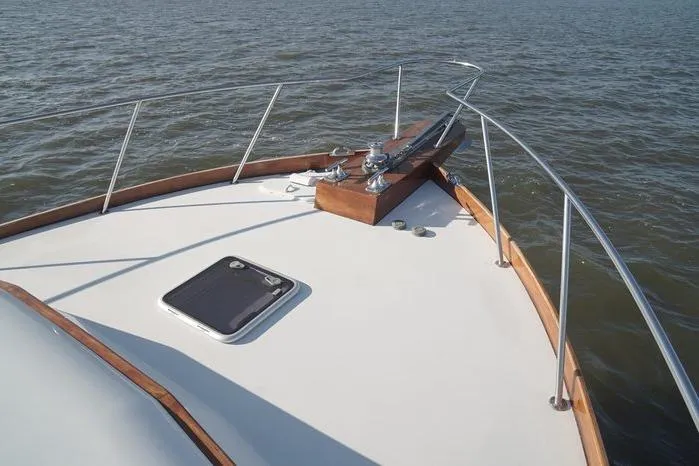 Slide: The Image of Bow of 2003 Huckins Atlantic 44 yacht on open water, featuring sleek design and railing. - 10