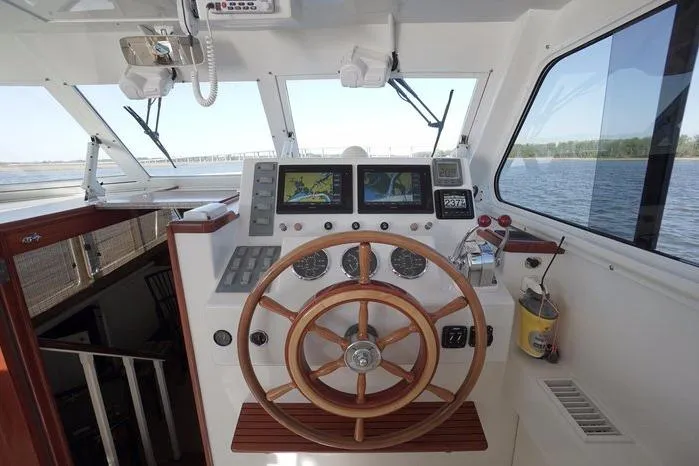 Slide: The Image of Helm of 2003 Huckins Atlantic 44 yacht with wooden steering wheel and navigation screens. - 15