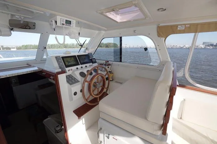 Slide: The Image of Helm of 2003 Huckins Atlantic 44 yacht with wooden steering wheel and navigation equipment. - 18