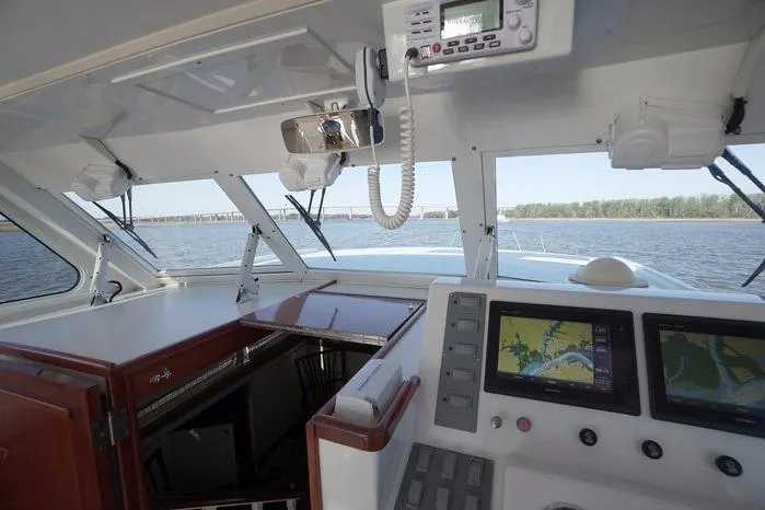 Slide: The Image of Cockpit view of 2003 Huckins Atlantic 44 yacht with navigation equipment and water scenery. - 21