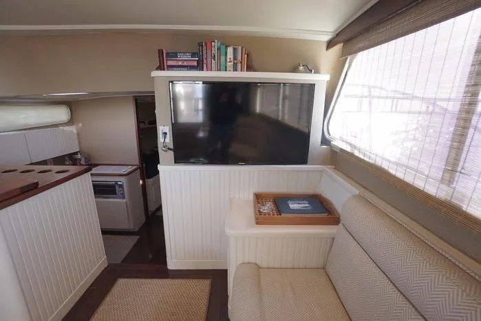 Slide: The Image of Interior of 2003 Huckins Atlantic 44 yacht with TV, seating, and books. - 24