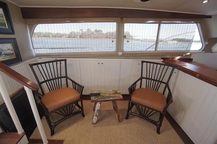 Slide: The Image of Interior of 2003 Huckins Atlantic 44 yacht with two chairs and a small table. - 26