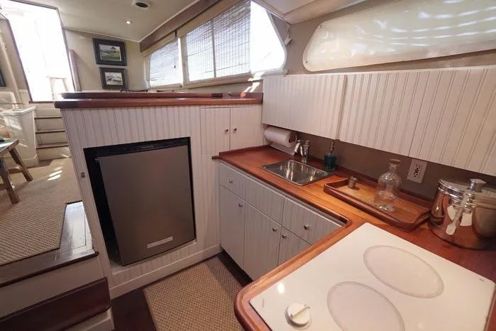 Slide: The Image of Interior of 2003 Huckins Atlantic 44 yacht kitchen with modern amenities and wood accents. - 28