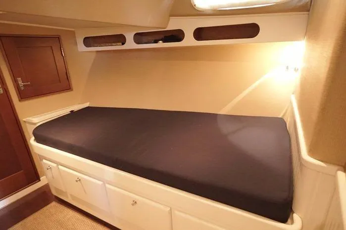 Slide: The Image of Cozy cabin interior of 2003 Huckins Atlantic 44 yacht with single bed and storage. - 33