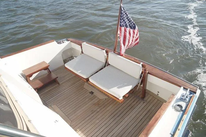 Slide: The Image of 2003 Huckins Atlantic 44 boat deck with seating and American flag on water. - 5