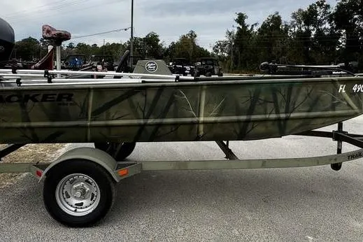 Slide: The Image of 2007 Tracker Grizzly 1654 SC boat on trailer, camo design, parked outdoors. - 2