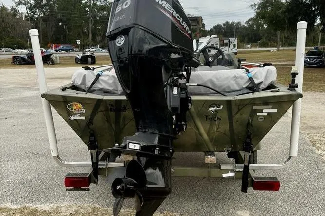 Slide: The Image of 2007 Tracker Grizzly 1654 SC boat with Mercury outboard motor, parked on a trailer. - 3