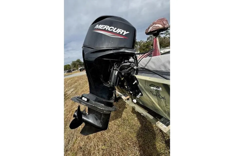 Slide: The Image of 2007 Tracker Grizzly 1654 SC boat with Mercury outboard motor on grassy area. - 4