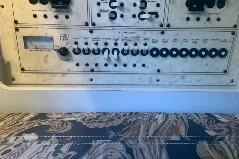 Slide: The Image of Control panel of a 1998 Cruisers 3375 Espirit boat, featuring various switches and gauges. - 34