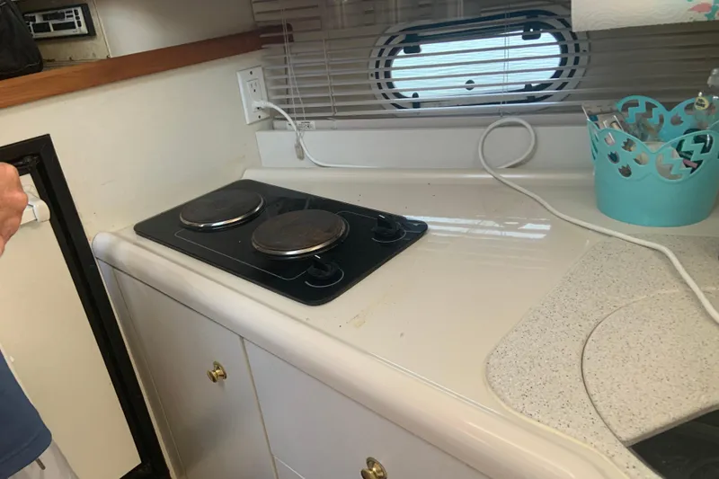 Slide: The Image of 1998 Cruisers 3375 Espirit yacht kitchen with electric stove and countertop accessories. - 35