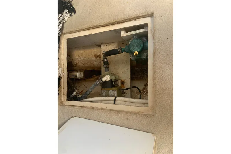 Slide: The Image of 1998 Cruisers 3375 Espirit boat interior compartment with visible plumbing and wiring. - 43