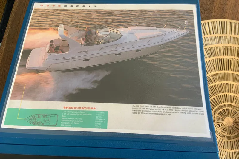 Slide: The Image of 1998 Cruisers 3375 Espirit boat brochure on a wooden table, showcasing specifications. - 53