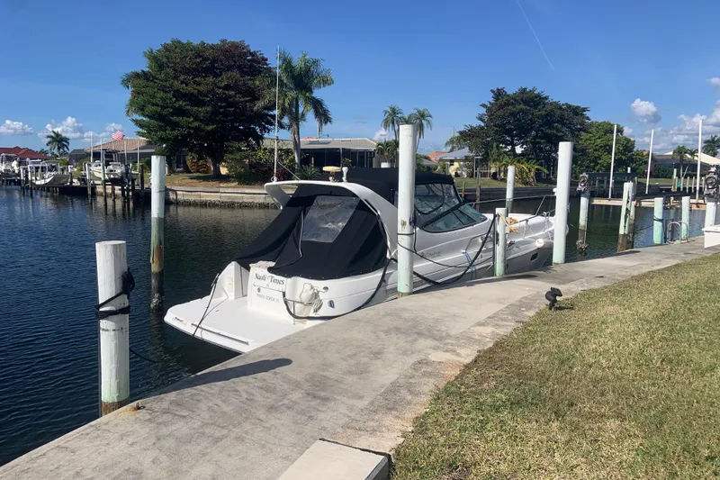 Slide: The Image of 1998 Cruisers 3375 Esprit yacht docked in a scenic marina with palm trees. - 6
