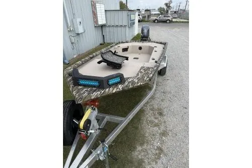 Slide: The Image of 2026 Avid 16 Commander boat on trailer, camo design, parked outdoors. - 3