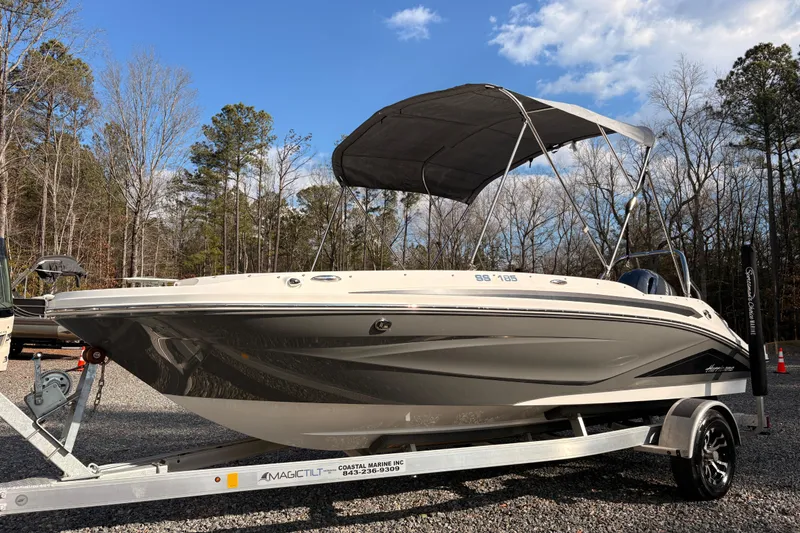 The Image of 2022 Hurricane SunDeck Sport 185 OB boat on trailer, parked outdoors under blue sky. - 1