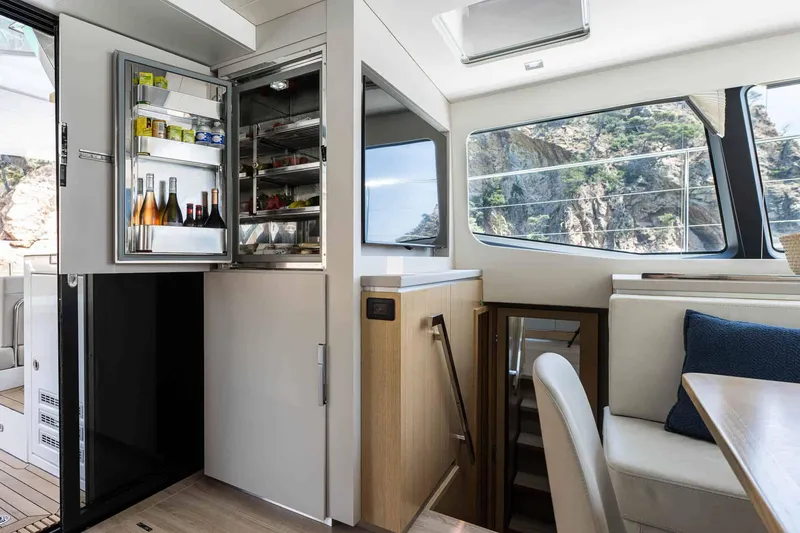 Slide: The Image of Luxury interior of 2025 Privilege Signature 580 yacht with open fridge and scenic view. - 45