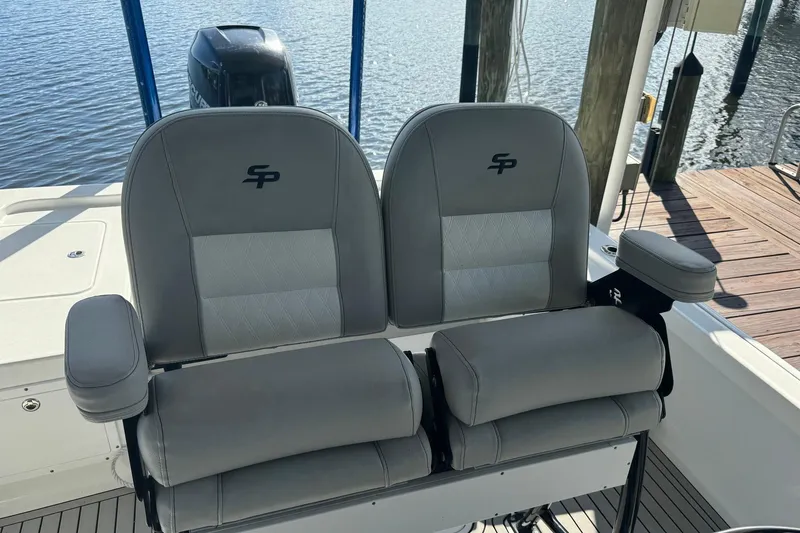 Slide: The Image of 2019 Sea Pro 248 Bay boat seats with logo, docked by water. - 11