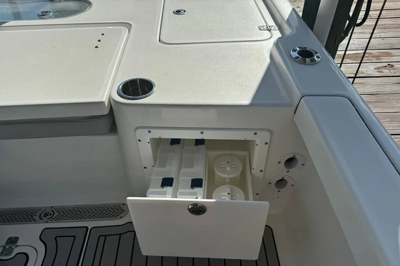 Slide: The Image of 2019 Sea Pro 248 Bay boat storage compartment with cup holders and deck details. - 13