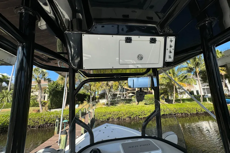 Slide: The Image of 2019 Sea Pro 248 Bay boat interior with console and lush waterfront view. - 14