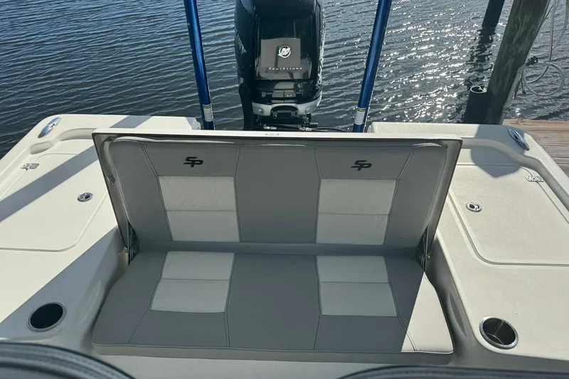 Slide: The Image of 2019 Sea Pro 248 Bay boat with cushioned seating and outboard motor, docked by the water. - 6