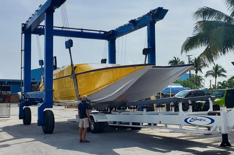 Slide: The Image of Yellow 2005 Thriller Powerboats Super Cat 55 on trailer, palm trees in background. - 12