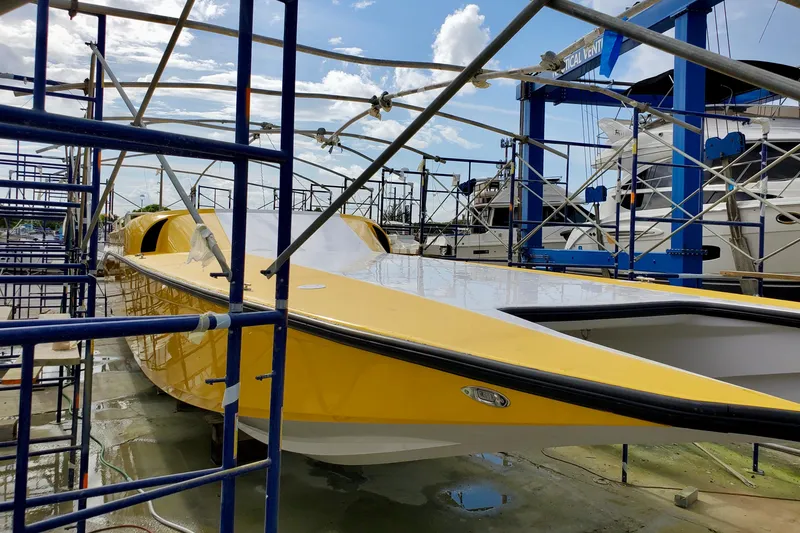 Slide: The Image of Yellow 2005 Thriller Powerboats Super Cat 55 in dry dock, surrounded by scaffolding. - 13