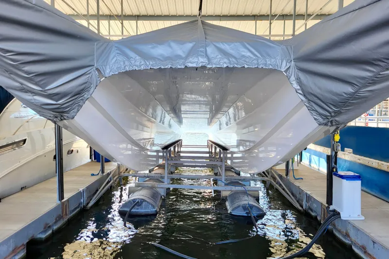 Slide: The Image of 2005 Thriller Powerboats Super Cat 55 in dock, covered and elevated above water. - 26