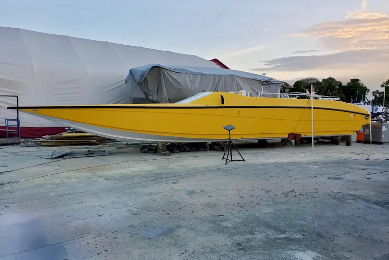 Slide: The Image of Yellow 2005 Thriller Powerboats Super Cat 55 on dry dock at sunset. - 29
