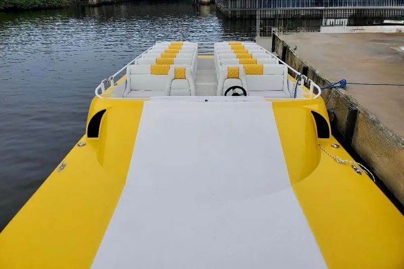 Slide: The Image of 2005 Thriller Powerboats Super Cat 55, yellow and white, docked by the water. - 3