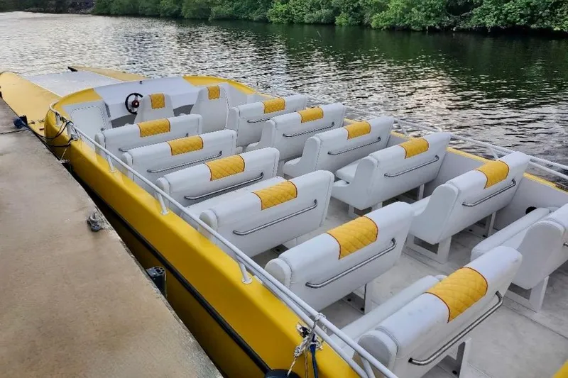 Slide: The Image of 2005 Thriller Powerboats Super Cat 55 with yellow and white seating, docked by a river. - 5