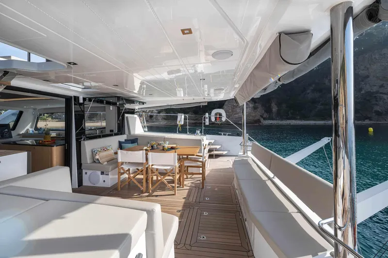 Slide: The Image of Luxurious 2025 Privilege Signature 580 yacht deck with elegant seating and dining area. - 23