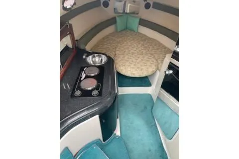 Slide: The Image of 1996 Donzi 275 LXC cabin interior with teal accents and compact kitchen area. - 12