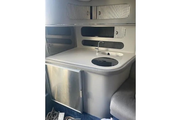 Slide: The Image of 1996 Donzi 275 LXC boat interior with kitchenette, sink, and storage. - 19