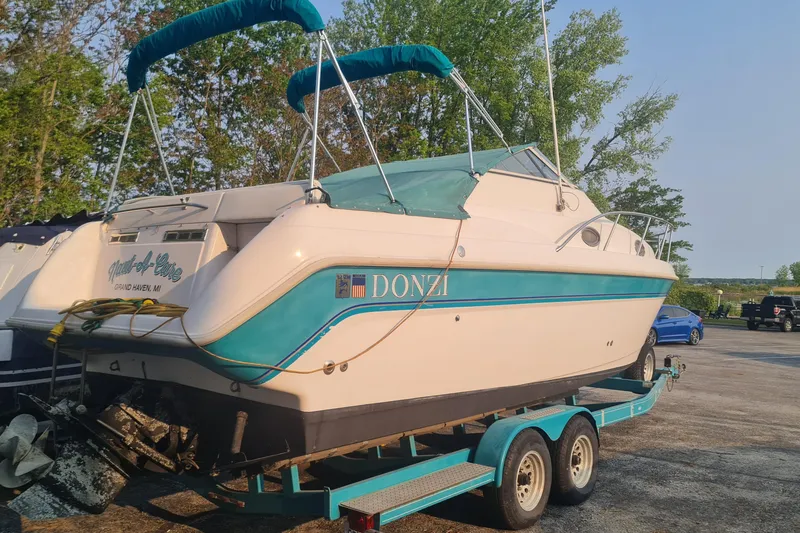 Slide: The Image of 1996 Donzi 275 LXC boat on trailer, teal and white, parked outdoors. - 3
