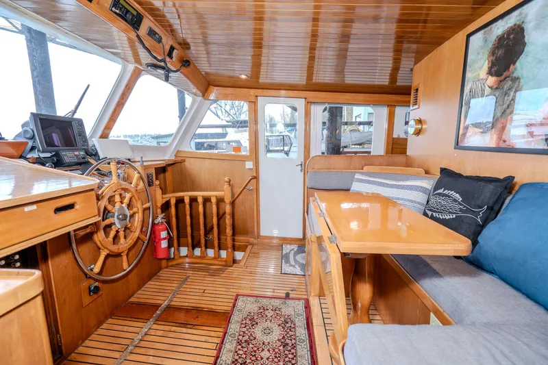 Slide: The Image of Interior of 1973 American Marine Alaskan 53 yacht with wooden helm and cozy seating area. - 10