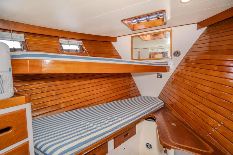 Slide: The Image of 1973 American Marine Alaskan 53 yacht cabin with wooden interior and striped bedding. - 28