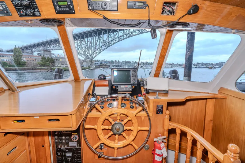 Slide: The Image of 1973 American Marine Alaskan 53 yacht helm with bridge view, featuring wooden interior and navigation equipment. - 3