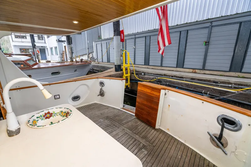 Slide: The Image of 1973 American Marine Alaskan 53 yacht deck with sink, wooden flooring, and American flag. - 42